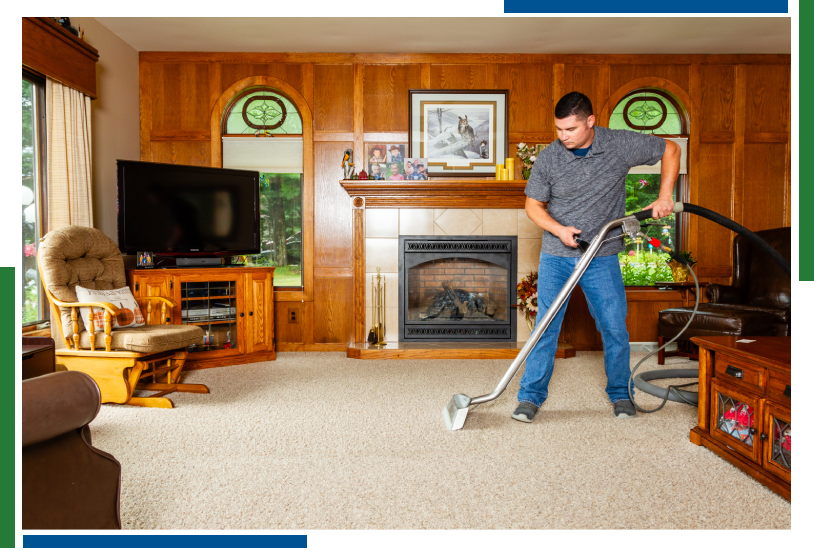 A man is vacuuming the floor in his living room.